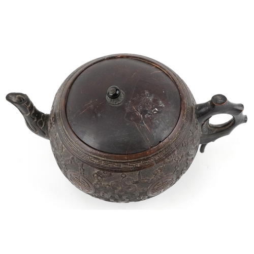 59 - A Chinese carved coconut teapot decorated with scrolling foliage, 10cm high.