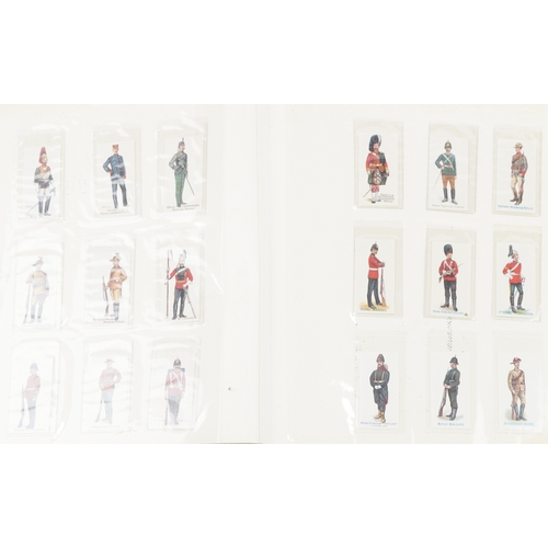 1304 - A large collection of military interest cigarette cards, some silk, arranged in three albums and Pap... 