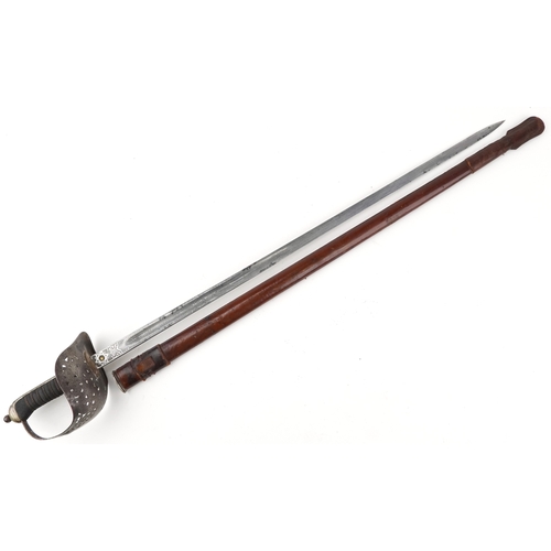 1308 - A British military World War I sword and scabbard with wire bound shagreen grip, the steel blade eng... 