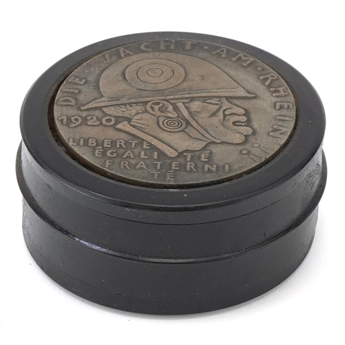 A German military interest ebonised snuff box, 6.5cm in diameter.