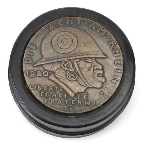 A German military interest ebonised snuff box, 6.5cm in diameter.