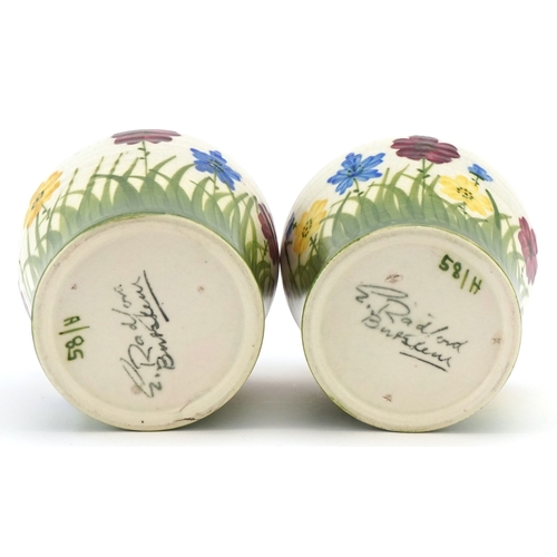 223 - E. Radford, a pair of Art Deco pottery vases, each with hand painted floral decoration, each bearing... 