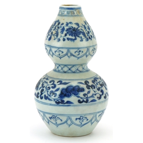 115 - A Chinese blue and white porcelain double gourd vase hand painted with scrolling foliage, 21cm high.