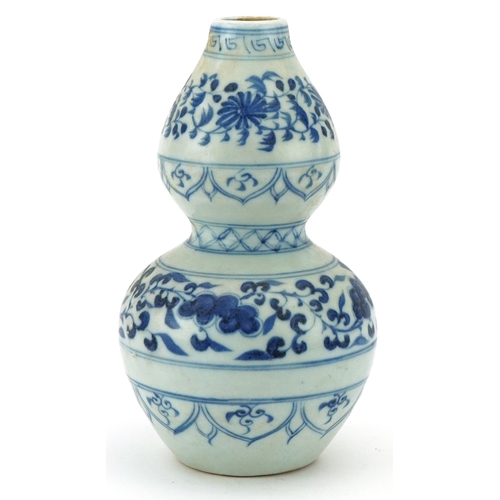 115 - A Chinese blue and white porcelain double gourd vase hand painted with scrolling foliage, 21cm high.