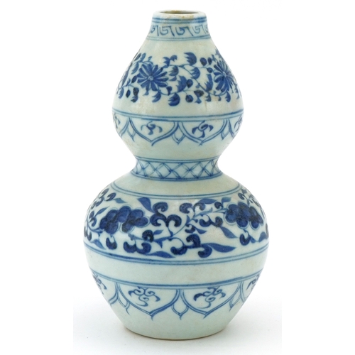 115 - A Chinese blue and white porcelain double gourd vase hand painted with scrolling foliage, 21cm high.
