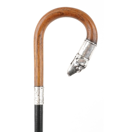An Edwardian ebonised walking stick with silver mounted hinged dog's head handle, Birmingham 1909, 86cm in length.