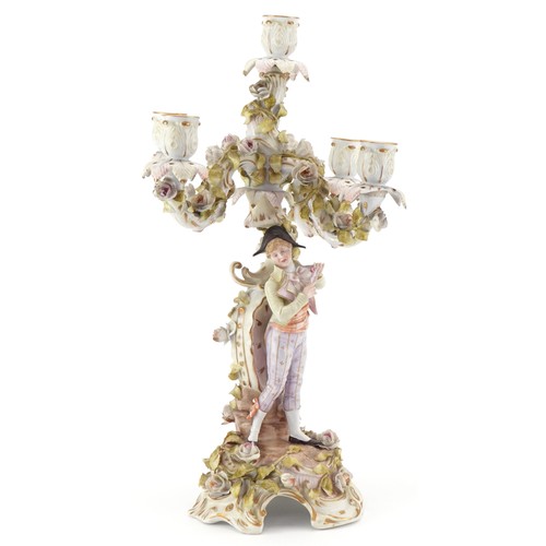100 - A Continental porcelain candelabra modelled as an 18th century boy with foliate decoration, the larg... 