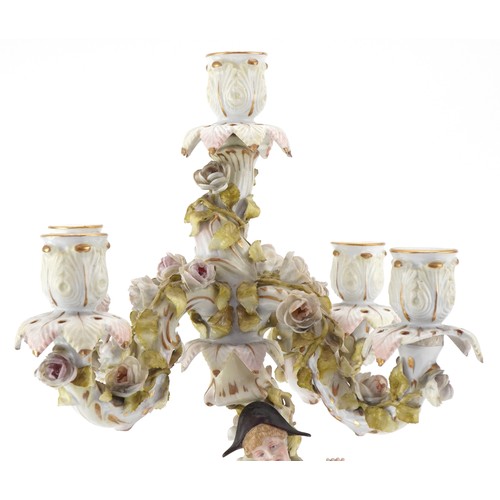 100 - A Continental porcelain candelabra modelled as an 18th century boy with foliate decoration, the larg... 