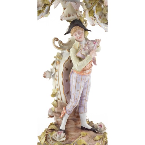 100 - A Continental porcelain candelabra modelled as an 18th century boy with foliate decoration, the larg... 