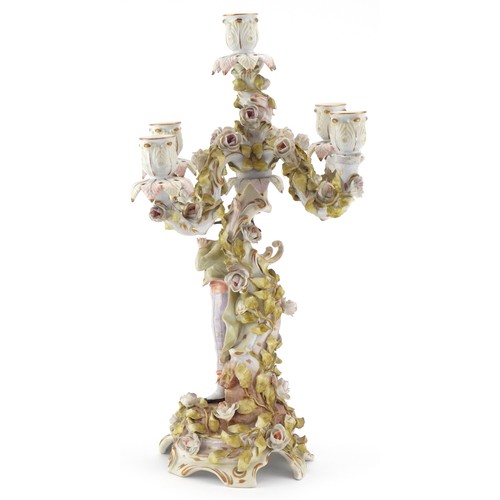 100 - A Continental porcelain candelabra modelled as an 18th century boy with foliate decoration, the larg... 