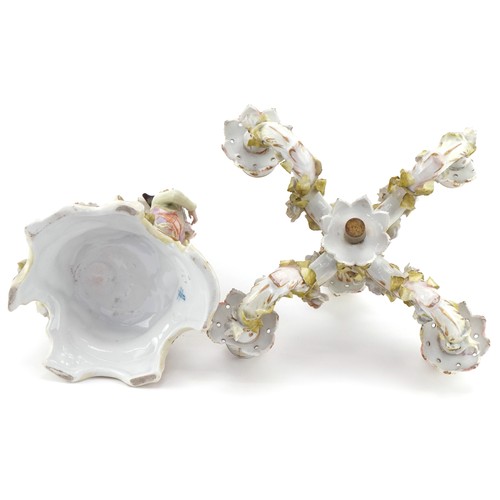 100 - A Continental porcelain candelabra modelled as an 18th century boy with foliate decoration, the larg... 