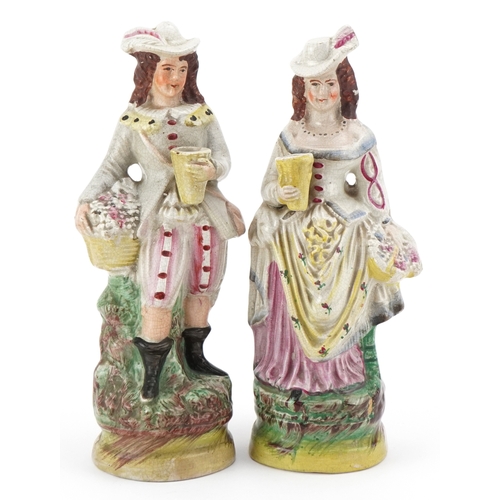 86 - A pair of early 20th century Staffordshire pottery figures, the largest 26cm high.