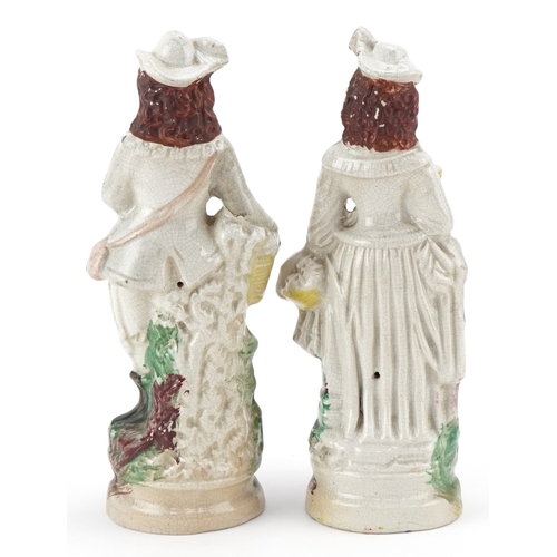 86 - A pair of early 20th century Staffordshire pottery figures, the largest 26cm high.