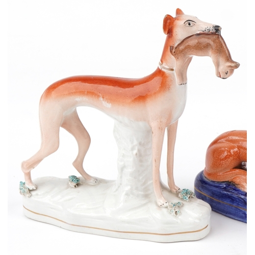89 - Three Victorian Staffordshire pottery figures of Greyhounds, the largest 20cm high.