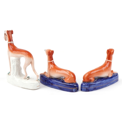 89 - Three Victorian Staffordshire pottery figures of Greyhounds, the largest 20cm high.