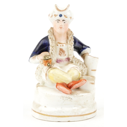 87 - A Victorian Staffordshire hand painted porcelain figure of a seated Sultan, 12.5cm high.