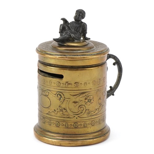 75 - A Grand Tour style brass moneybox with embossed neo-classical decoration and white metal mount in th... 