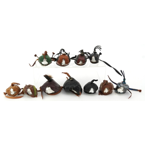 83 - Eleven vintage leather and fabric bird of prey falconry hoods, some with labels to the interior incl... 