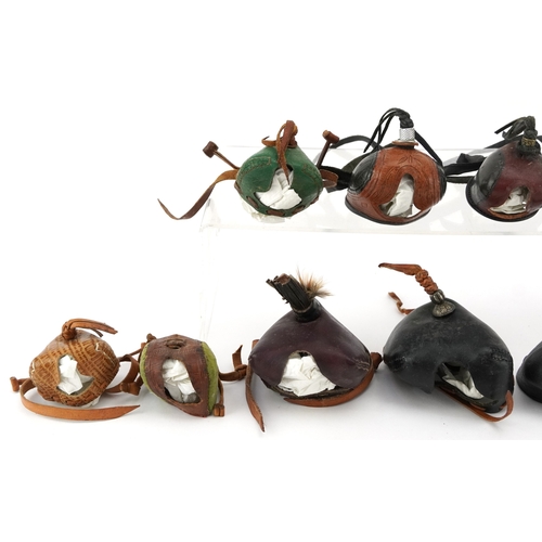 83 - Eleven vintage leather and fabric bird of prey falconry hoods, some with labels to the interior incl... 
