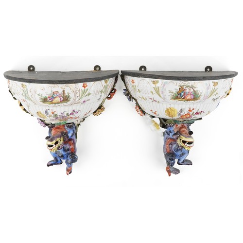 226 - A pair of Continental porcelain wall brackets with Chinese dogs of Foo supports hand painted with co... 