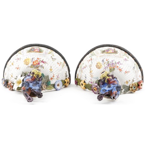 226 - A pair of Continental porcelain wall brackets with Chinese dogs of Foo supports hand painted with co... 