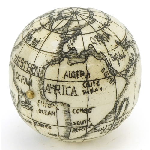 49 - A scrimshaw style etched bone compass in the form of a globe, 4cm in diameter.