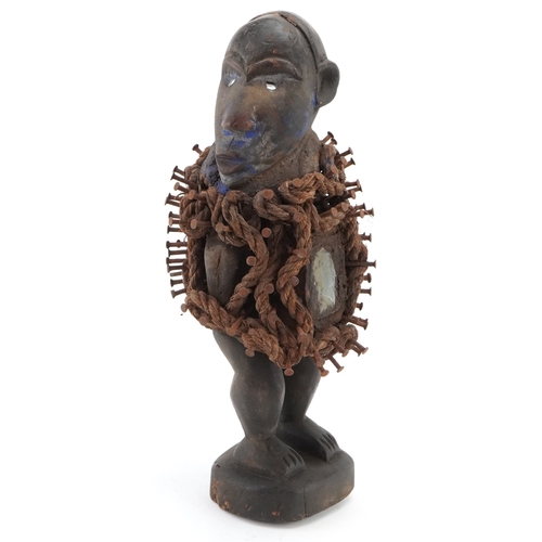 269 - An African carved ebony Nkisi Nkondi (Nail fetish figure) having hammered nails and rope around the ... 