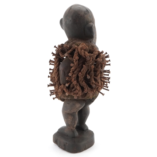 269 - An African carved ebony Nkisi Nkondi (Nail fetish figure) having hammered nails and rope around the ... 