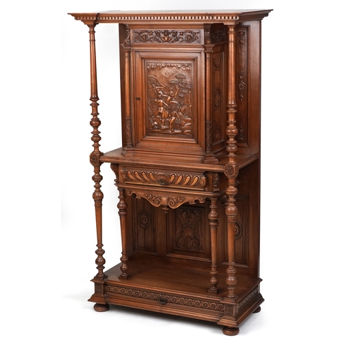 A late 19th century Italian Renaissance Revival carved walnut side cabinet, the inverted break front pediment above a carved panel door depicting nude maidens above a drawer and open shelf, the base fitted with a drawer on turned bun feet, 177cm H x 103cm W x 48cm D.