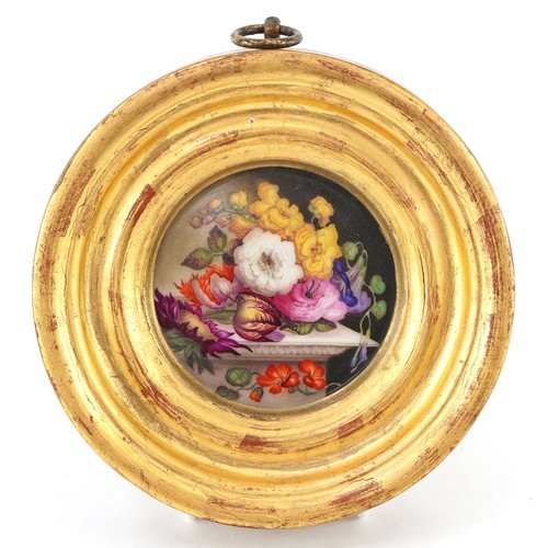 36 - Two 19th century porcelain plaques hand painted with flowers, each housed in a circular gilt frame, ... 