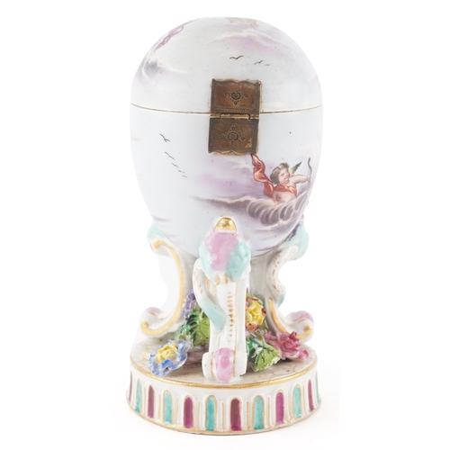 38 - A 19th century continental porcelain cup and cover with hand painted decoration, raised on scroll su... 