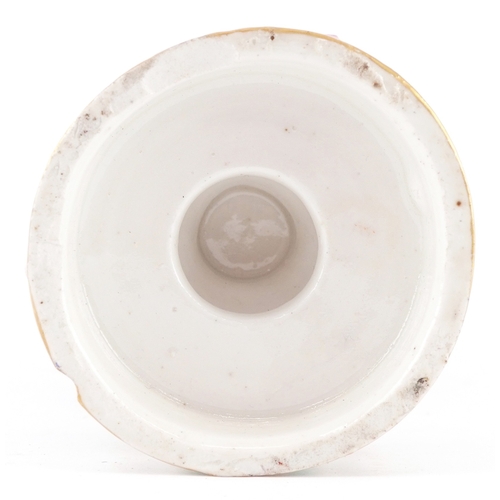 38 - A 19th century continental porcelain cup and cover with hand painted decoration, raised on scroll su... 