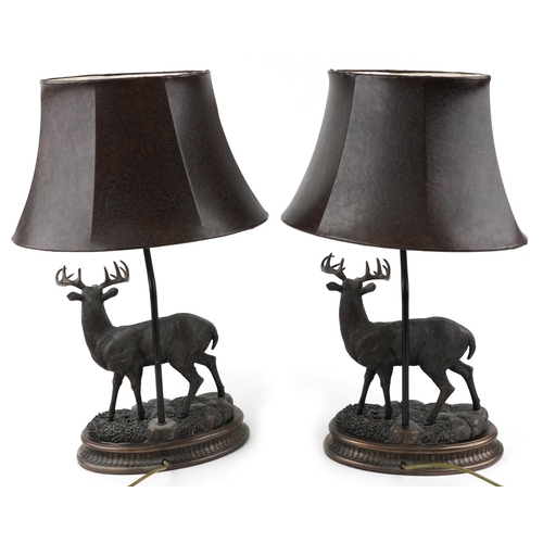 9 - A pair of bronze table lamps and shades in the form of stags, 66cm high.