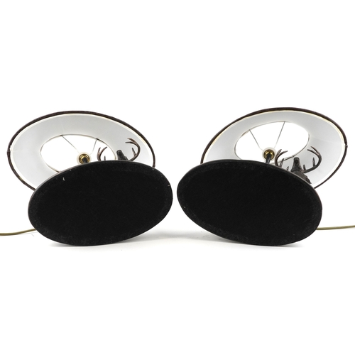 9 - A pair of bronze table lamps and shades in the form of stags, 66cm high.