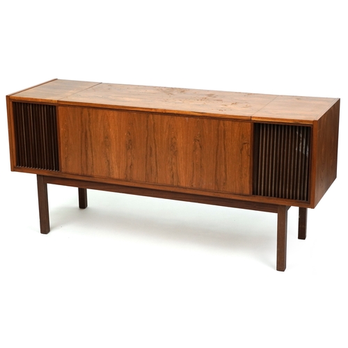 A mid 20th century rosewood sideboard by Carrousel the hinged lid revealing a Garrard record player and Arena radio, raised on block legs, 68cm H x 146cm W x 44cm D.