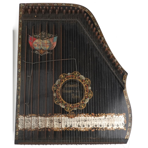 A German ebonised zither decorated with melody notes and gilded ...
