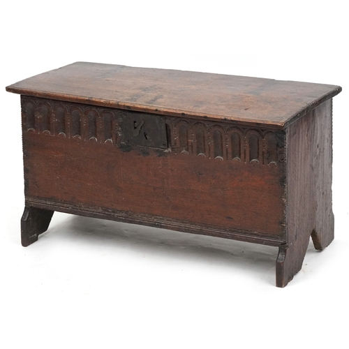 An 18th century six plank coffer, the hinged lid above a carved frieze, raised on stile supports, 45cm H x 84cm W x 36cm D.