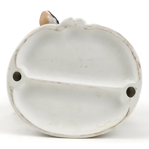 604 - A 20th century porcelain figure group of an accordion player with a dog and two perched birds, 19cm ... 