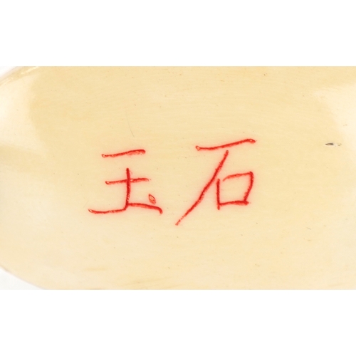 155 - A Japanese bone four section inro carved with an erotic couple and a bird, 6cm high.