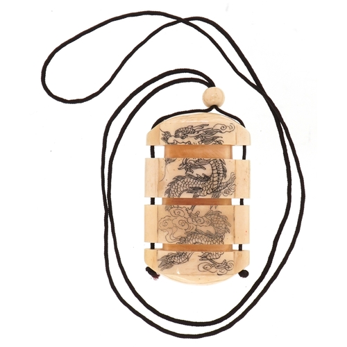 154 - A Japanese bone four section inro carved with an erotic couple and a dragon, 6cm high.