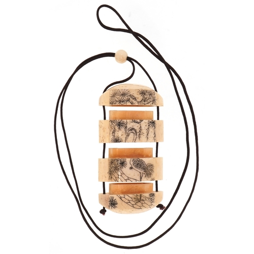 157 - A Japanese bone four section inro carved with an erotic couple and a crane, 5.5cm high.