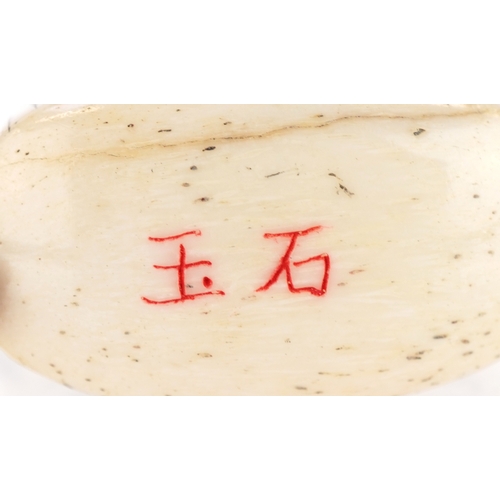 157 - A Japanese bone four section inro carved with an erotic couple and a crane, 5.5cm high.