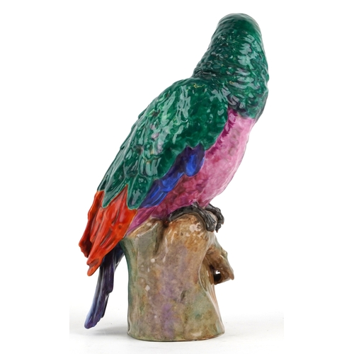 38 - A Meissen style porcelain parrot perched on a branch, under glazed R mark to the base, 27cm high.