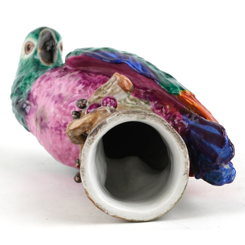 38 - A Meissen style porcelain parrot perched on a branch, under glazed R mark to the base, 27cm high.