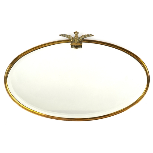 2021 - An early 20th century oval bevelled glass and brass mirror with stylized leaf design, 76cm wide.