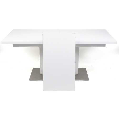 2049 - A modern white extending dining table, the rectangular top drawing out to reveal an additional extra... 