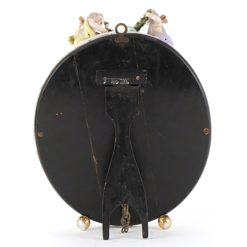 27 - A Sitzendorf German porcelain oval easel mirror with encrusted floral decoration and surmounted with... 