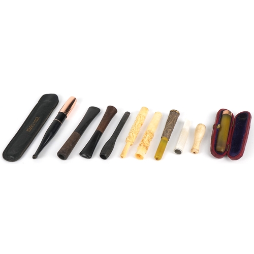 297 - A collection of cheroot holders including a gold mounted example, the largest 10cm in length.