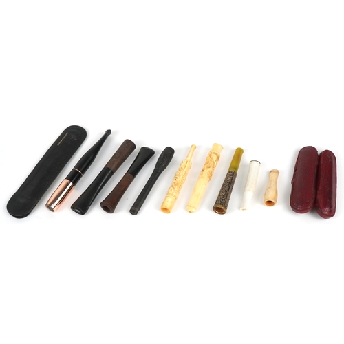297 - A collection of cheroot holders including a gold mounted example, the largest 10cm in length.