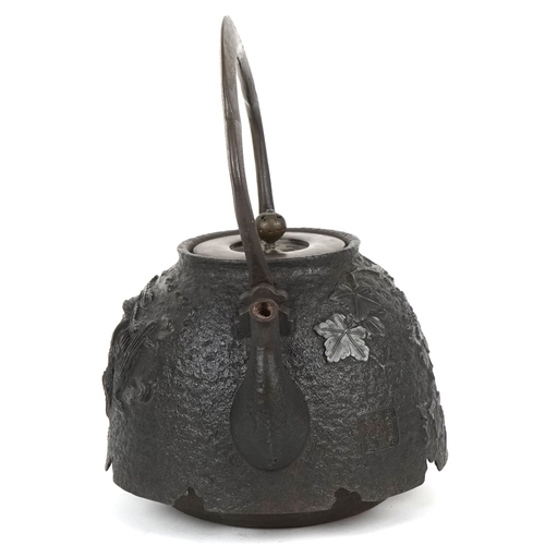  A Japanese cast iron teapot, 19th century, decorated with a phoenix bearing a nine character mark to... 